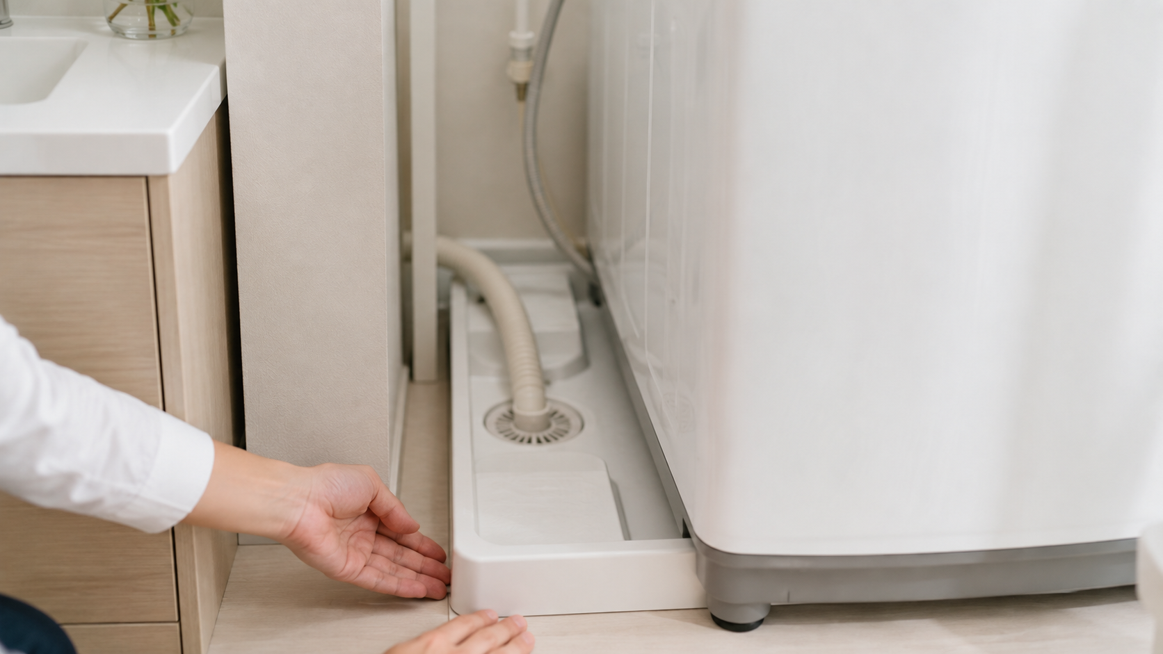 洗濯機まわりの防水パンやホースを確認する様子